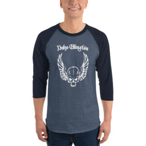 A smiling man wears a dark heather blue and navy 3/4 sleeve raglan shirt featuring a white skull with wings graphic and the words “Duke Ellington” in gothic lettering above.