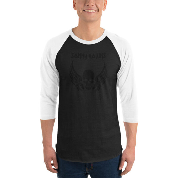 Black and white raglan baseball shirt with subtle black-on-black graphic of a skull with wings and matching “Sonny Rollins” title, creating a stealthy, low-contrast look.