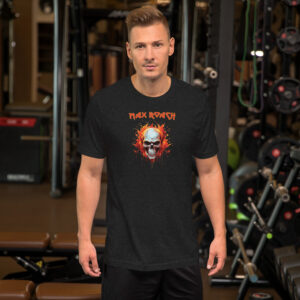 A man in a gym wears a black heather T-shirt featuring a fiery skull graphic with the words "MAX ROACH" in red punk-style lettering above it.