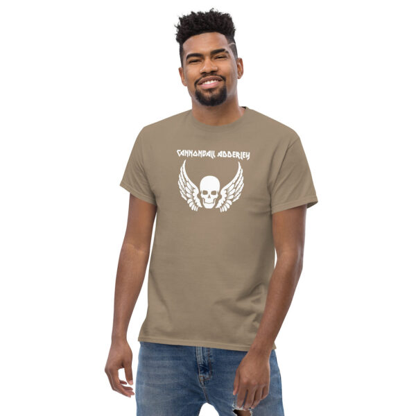 Man smiling in a taupe Cannonball Adderley graphic tee with white skull and wing design.