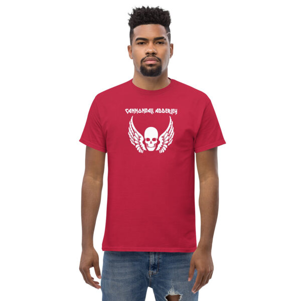 Front view of a man wearing a chocolate brown t-shirt with a central white graphic of a winged skull and the text “CANNONBALL ADDERLEY.”