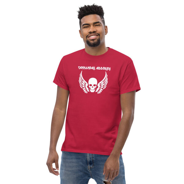 Man in a red t-shirt smiling, with a white graphic of a skull with feathered wings and the text “CANNONBALL ADDERLEY” in all caps.