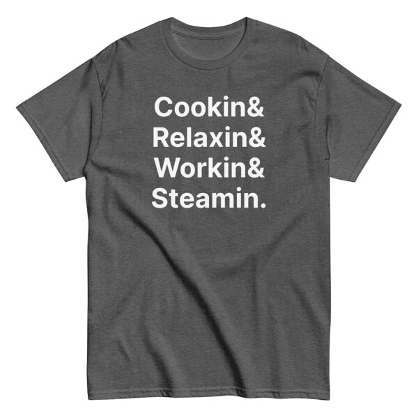 Dark heather gray t-shirt featuring the same white stacked phrase: “Cookin& / Relaxin& / Workin& / Steamin.”