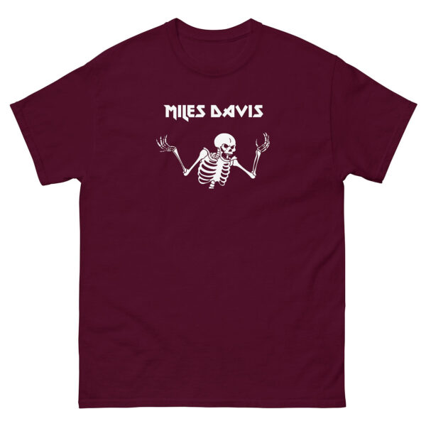 Maroon unisex t-shirt with a centered white illustration of a skeleton shrugging, paired with “Miles Davis” in angular lettering.