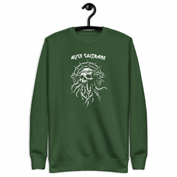 Green crewneck sweatshirt hanging on a black hanger, printed with a white graphic of a skeletal face framed by barbed lines and chaotic vines. The word “ALICE COLTRANE” appears in spiky uppercase letters above the image.