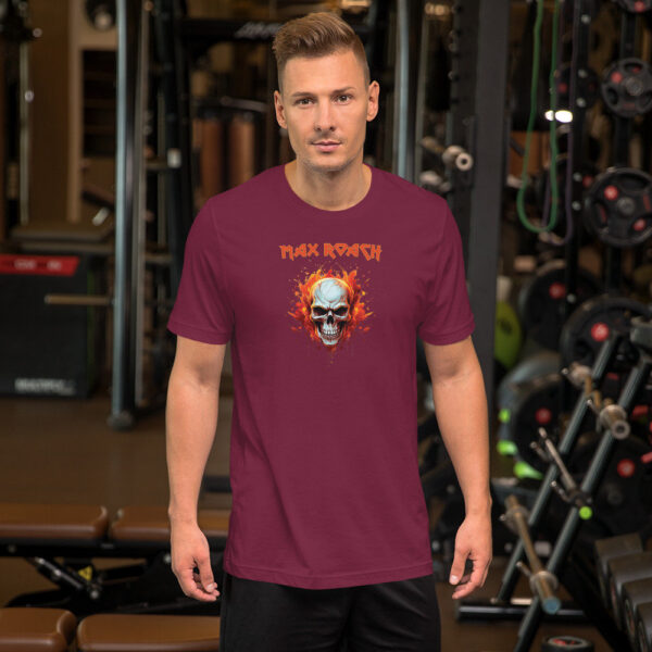 Man in a burgundy t-shirt featuring a flaming skull design and red "Max Roach" type, posed in a gym.