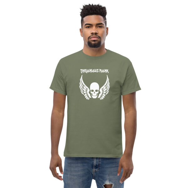 Man in olive green t-shirt with white winged skull illustration, with "THELONIOUS MONK" in bold white type above the central graphic.