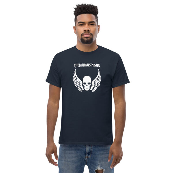 A man standing in a navy blue t-shirt with a centered white skull and wing graphic, with “Thelonious Monk” written in stylized white font above the design.