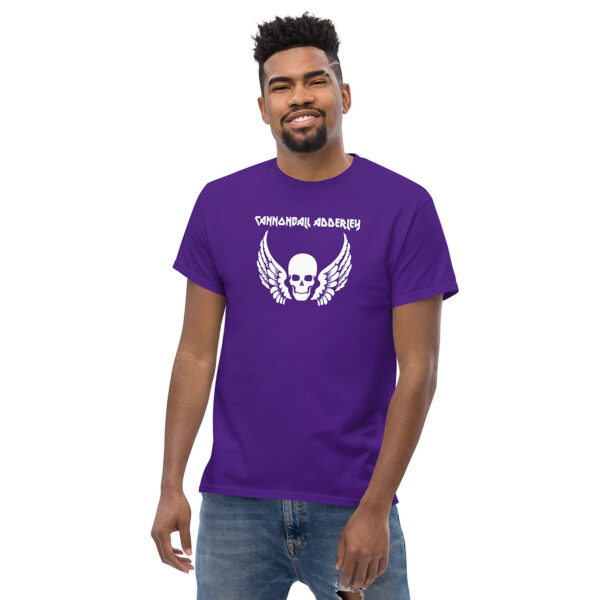 Man smiling in a purple t-shirt featuring a white skull with wings and the text "Cannonball Adderley."
