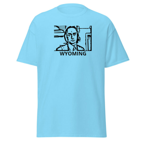 Light blue t-shirt printed with the same black line-art portrait of a man in a tie, framed in a rectangular box, with the word “WYOMING” in bold black letters beneath the image.
