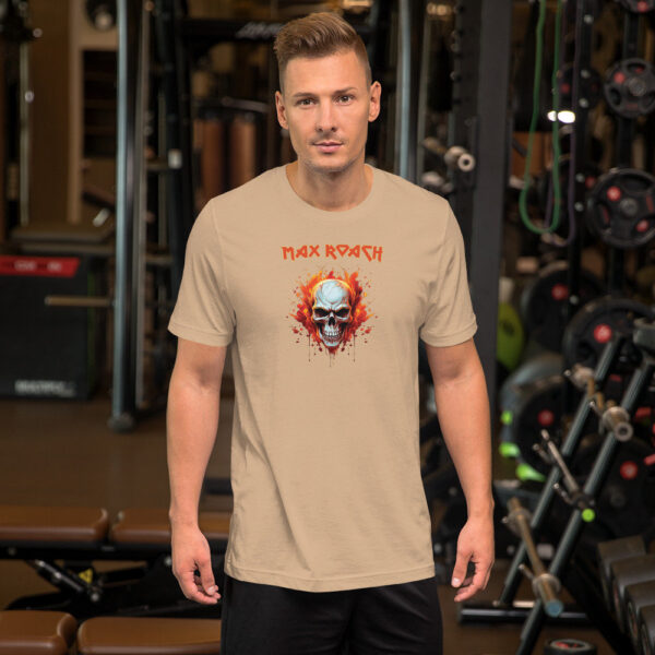 Man wearing a beige t-shirt with a flaming skull graphic and red "Max Roach" text above, standing in a gym setting.