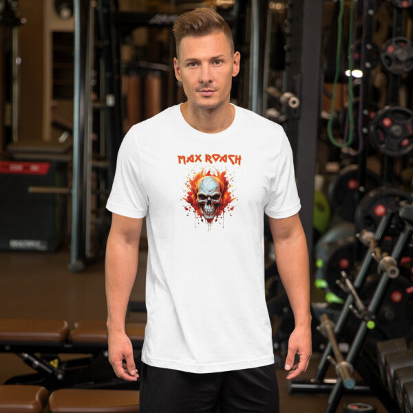 A man in a gym wearing a white t-shirt that features a flaming skull illustration with red splatters and the name “Max Roach” in red jagged text above.