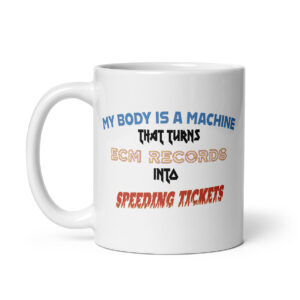 White ceramic mug featuring the phrase "My body is a machine that turns ECM records into speeding tickets" in stylized, multicolored fonts, centered on the front of the mug.