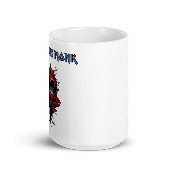 White ceramic mug featuring a graphic of a screaming red skull emerging from cracked black lines, with the name "Thelonious Monk" in bold, blue metal-style lettering above the design.
