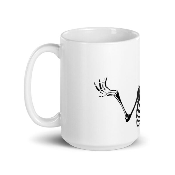 White ceramic mug with a black illustration of a skeleton’s raised arm and hand on the side, part of a wraparound design.