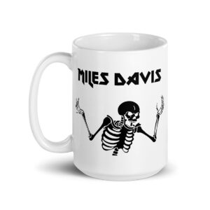 White ceramic mug featuring a black graphic of a skeleton with raised arms and the text "MILES DAVIS" in bold, angular font above the illustration.