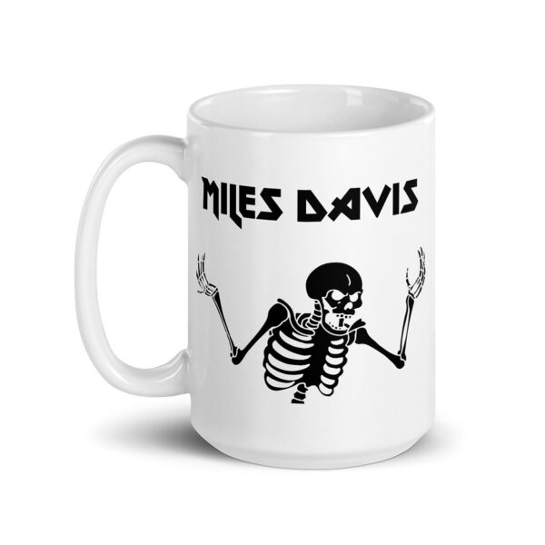 White ceramic mug featuring a black graphic of a skeleton with raised arms and the text "MILES DAVIS" in bold, angular font above the illustration.