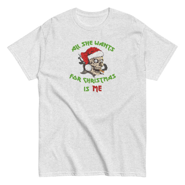 Light heather gray short-sleeve t-shirt featuring a cartoon skull wearing a Santa hat and smoking a cigarette. The graphic is surrounded by green and red text that reads: “All She Wants For Christmas Is Me.”