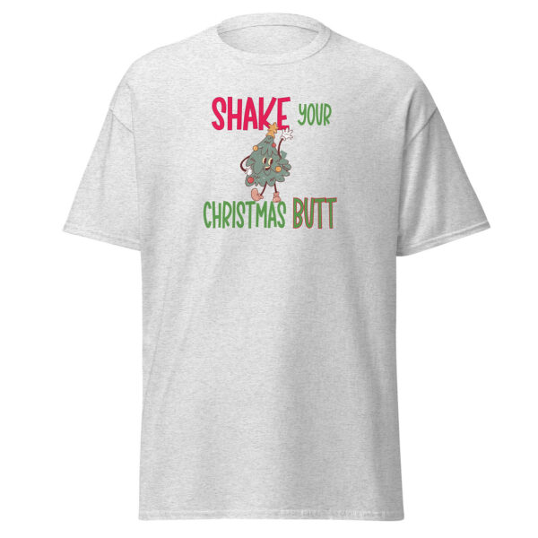 Light grey unisex T-shirt with a festive graphic of a cartoon Christmas tree dancing and the phrase "Shake Your Christmas Butt" in playful red, green, and brown lettering.