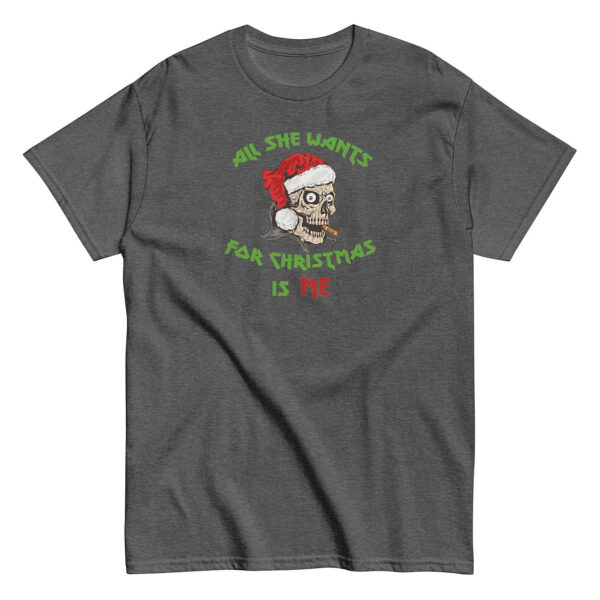 Dark gray short-sleeve t-shirt with a graphic of a cartoon skull in a red Santa hat, smoking a cigar. Above and below the skull, green and red bold text reads: "All She Wants For Christmas Is Me."