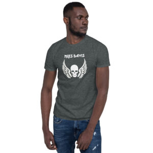 Front view of a heathered charcoal men’s fitted T-shirt with the same "Miles Davis" skull and wings graphic; the model stands casually with one hand in his pocket.