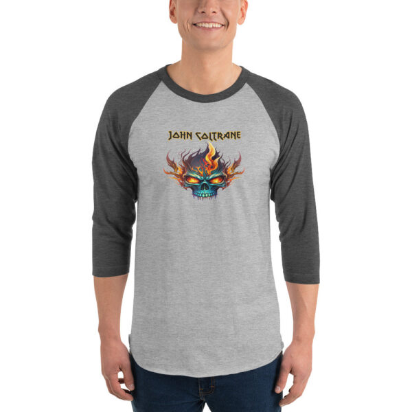 Grey and black raglan-sleeve shirt featuring a fiery skull graphic with the name John Coltrane in gold metal-style font above it