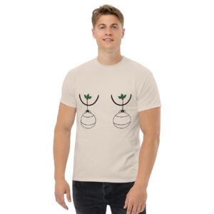 Man wearing a cream-colored T-shirt with a humorous Christmas design showing two ornaments hanging from holly sprigs, positioned over the chest.