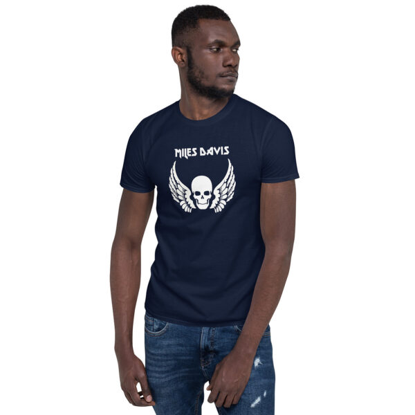 Front view of a navy blue men’s fitted T-shirt with the white skull and wings graphic and "Miles Davis" text; the model is looking to the side with one hand in his pocket.