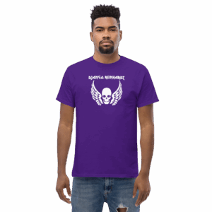Model wearing a purple t-shirt with a white “Django Reinhardt” skull and wings graphic, facing forward.
